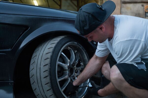Automobilių serviso meistras atlieka prevencinę automobilio techninę apžiūrą moderniame autoservise.